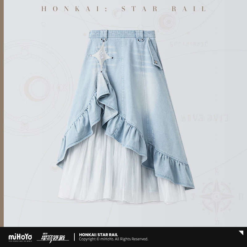 Cyrene — Layered Denim Skirt. A long skirt layering an asymmetric light-blue denim ruffle over a white pleated mesh section. Star accents, a high waistband and rear patch pockets echo Cyrene’s collection motifs.